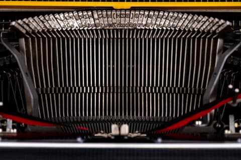 Eine gelbe Erika Schreibmaschine steht im Mittelpunkt des Fotos und erinnert an die Anfänge der Schreibtechnologie